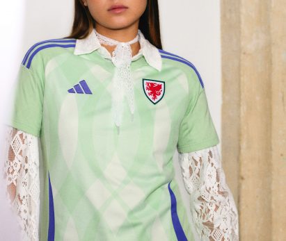 Light green football strip with purple details and dragon shield on chest