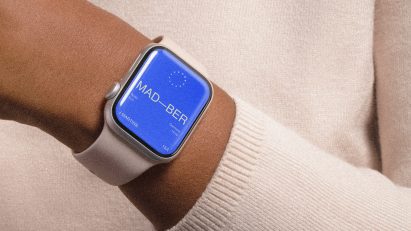 Composite image showing a rendering for a simple train travel app interface in bright blue on an Apple Watch on a person's hand