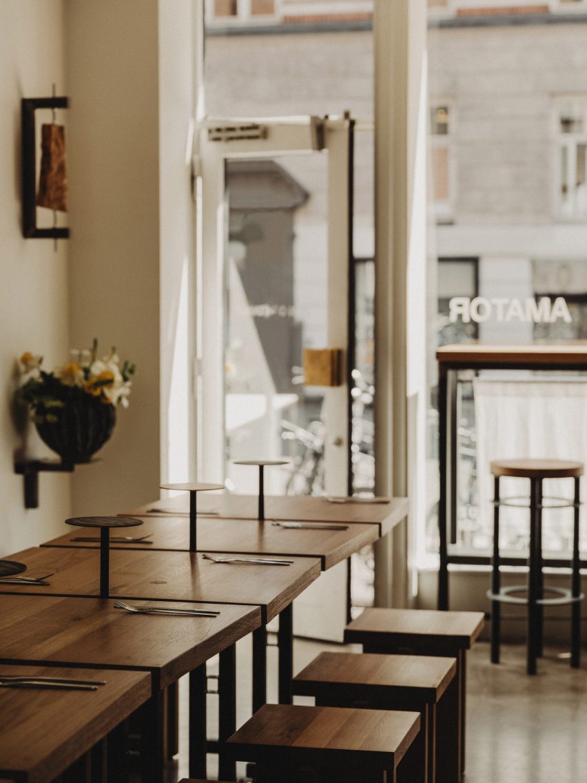 Photograph of the communal table area facing the large glass facade.