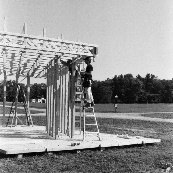 Black and white photo of people building a wooden structure