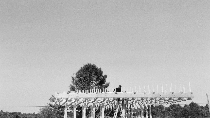 Black and white photo of people building a wooden structure