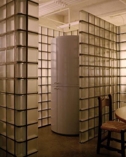 Glass blocks form a niche around a cylindrical blue bar cabinet