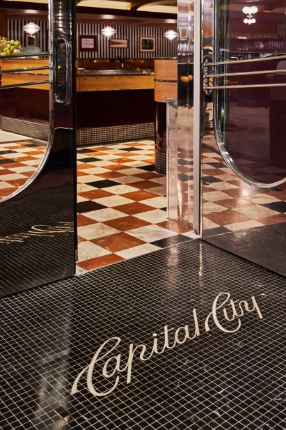 Restaurant entrance with black mosaic floor tiles inscribed with Capital City in white