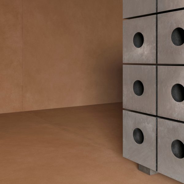 A cropped photograph of a piece of silver furniture against a brown tiled wall and floor