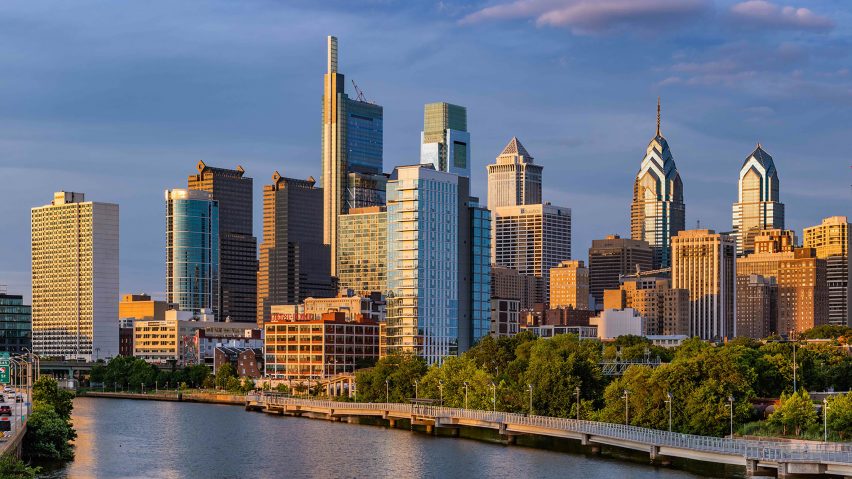 a photograph of a group of skyscrapers by a river