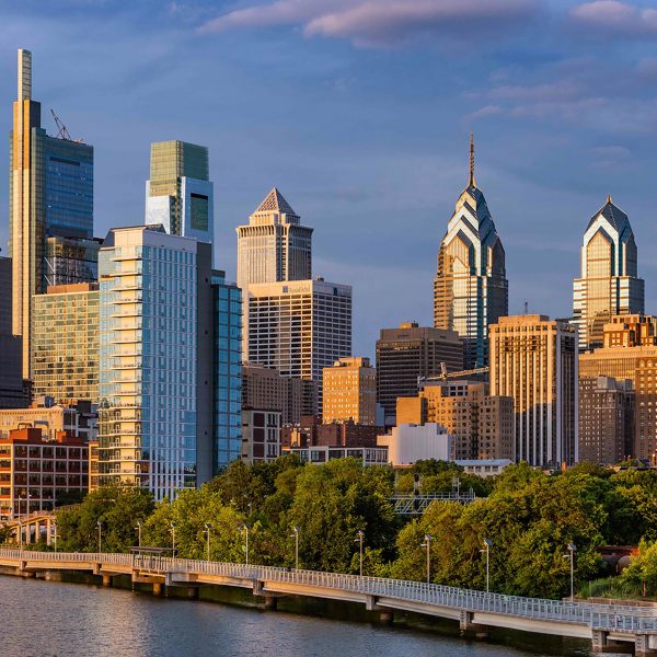 a photograph of a group of skyscrapers by a river