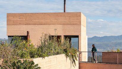 Board formed concrete house with mountains in the background