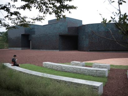 Stone seating outside tile-clad building