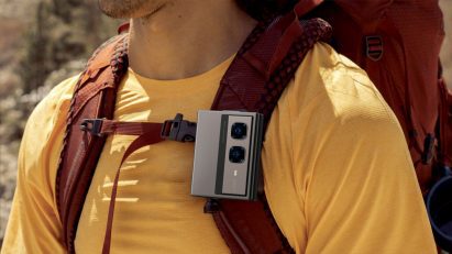 Close-up photo of a man's chest wearing an Infinix Zero Series Mini Tri-Fold phone clipped onto a backpack strap