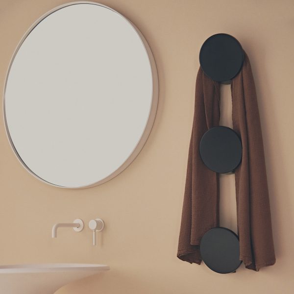 Towel rail with round mirror besides it