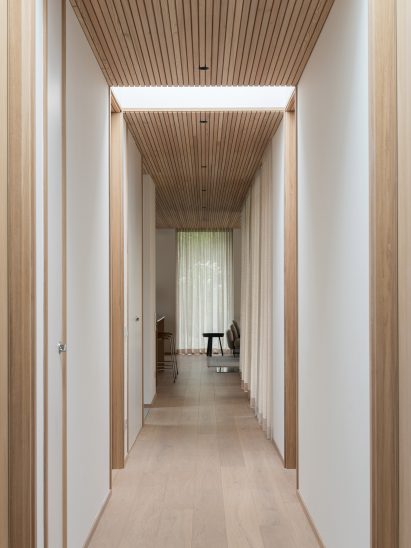 Corridor within wooden-clad home by Johan Sundberg Arkitektur
