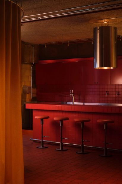 Red tiles and bar stools in dimly lit restaurant interior