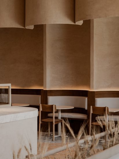 Walls lined in clay plaster and shaped to create niches for booth seating