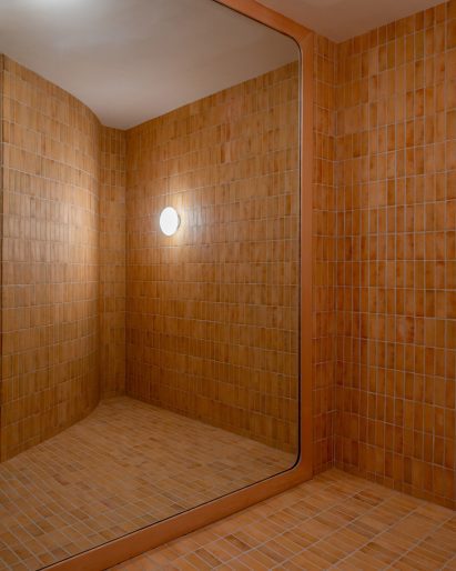 Tiles cover the walls and floor of a fitting room