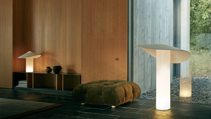 A photograph of a living room with a lamp placed atop a shelf and another on the floor.