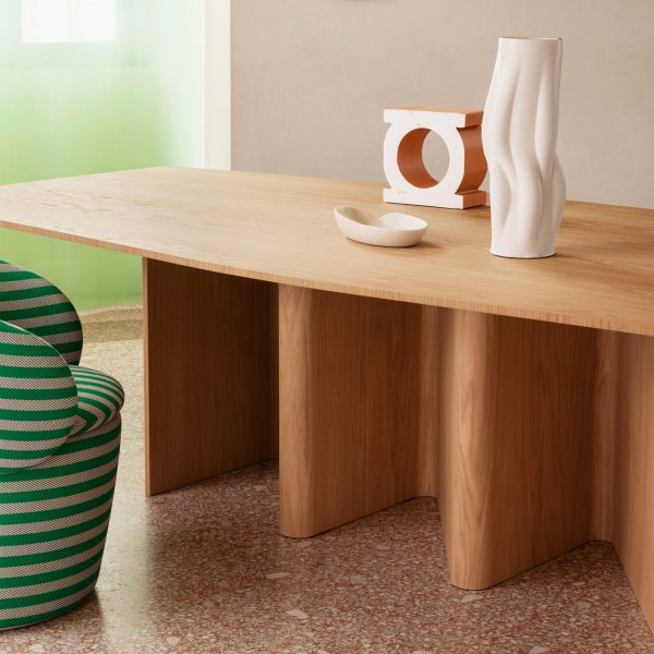 A cropped photograph of a brown wooden table with white ornaments on top of it