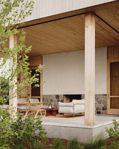 Covered porch with a fireplace and outdoor furniture