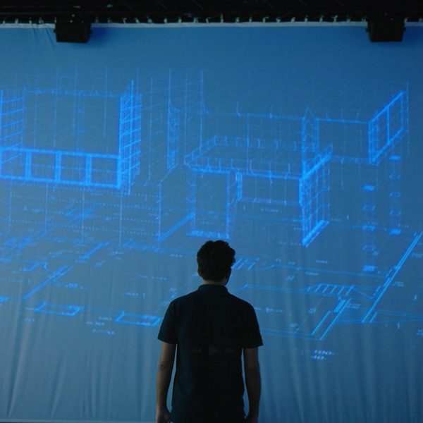 a photograph of a person in front of a projected screen