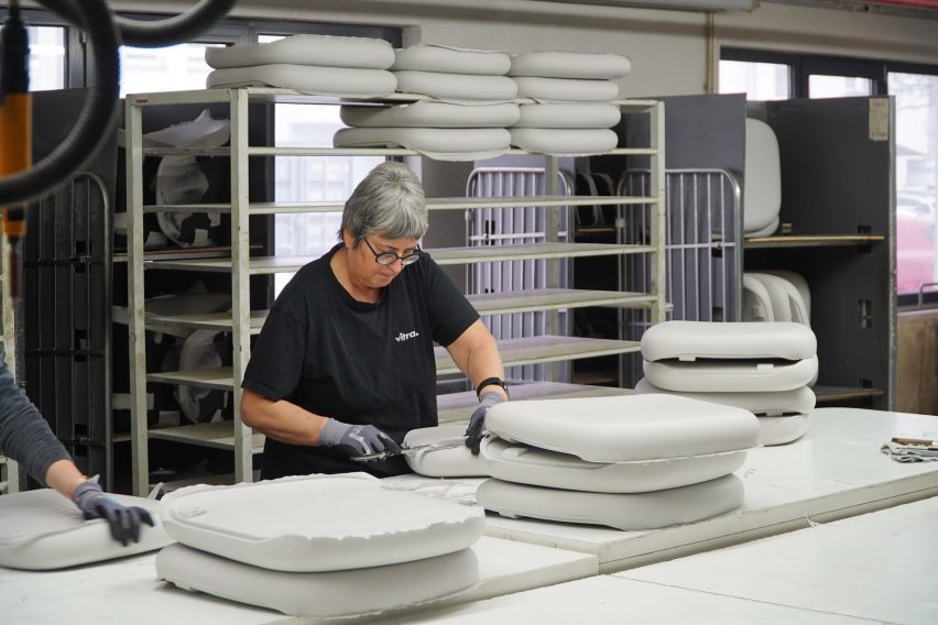 Photo of a woman cutting the excess edge material off from moulded foam seating pads in a factory