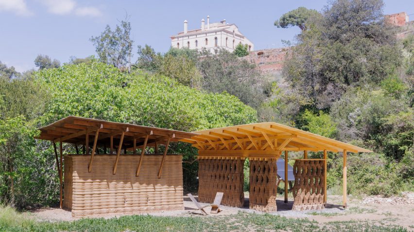 a photograph of a beige wooden structure amongst greenery