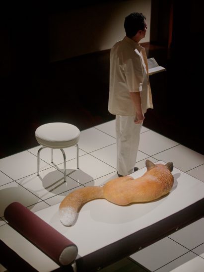 Plastic fox curled up on a chaise