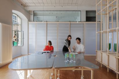 Photo of Claudia Pasquero sitting at a large table within the Design Apothecary in Turin while two colleagues look over some materials