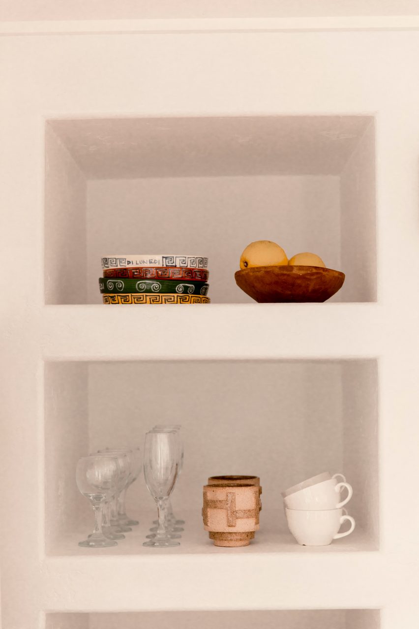 Ceramic mugs and glasses on deep thick shelves