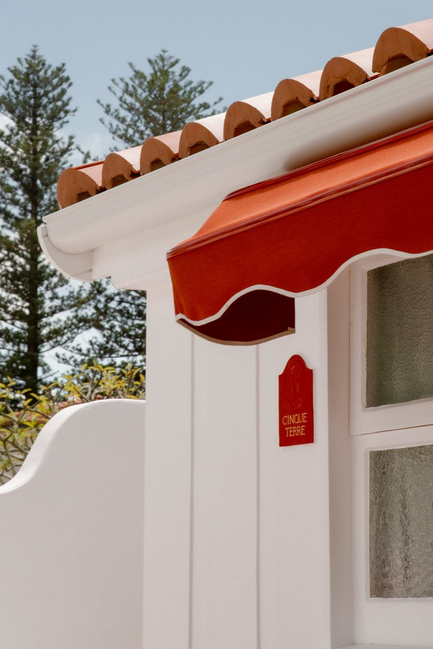 White washed stucco walls and red awning