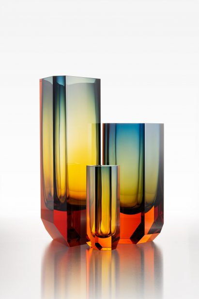 Three glass vases with an orange base that fades to yellow and blue