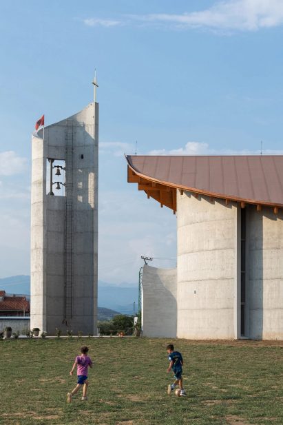 Curved concrete church with wooden roof