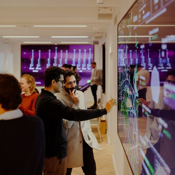 a photograph of people interacting with a purple screen in a room