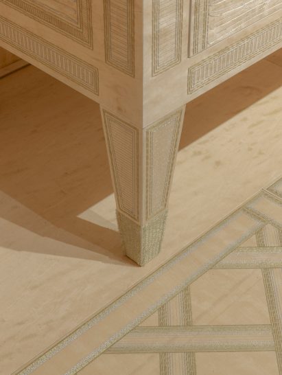 Legs of a wooden cabinet embroidered with metal thread