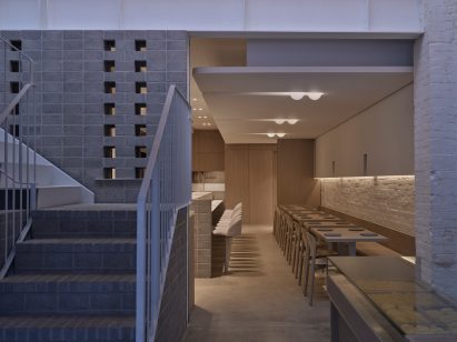 Restaurant interior with gray brick and wood interior at night