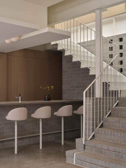 Restaurant with a minimalist palette of gray bricks, pale wood and a flour-white hue