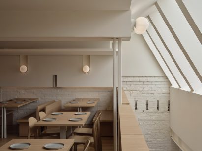 Angled skylights over a staircase bring light into both levels of a restaurant