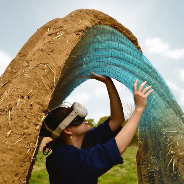 a photograph of a person wearing a VR headset underneath a brown circular structure