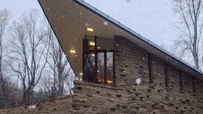Pointed stone-clad house in the snow