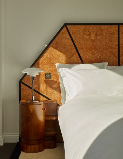 Burl wood headboard and white glass and chrome bedside lamp