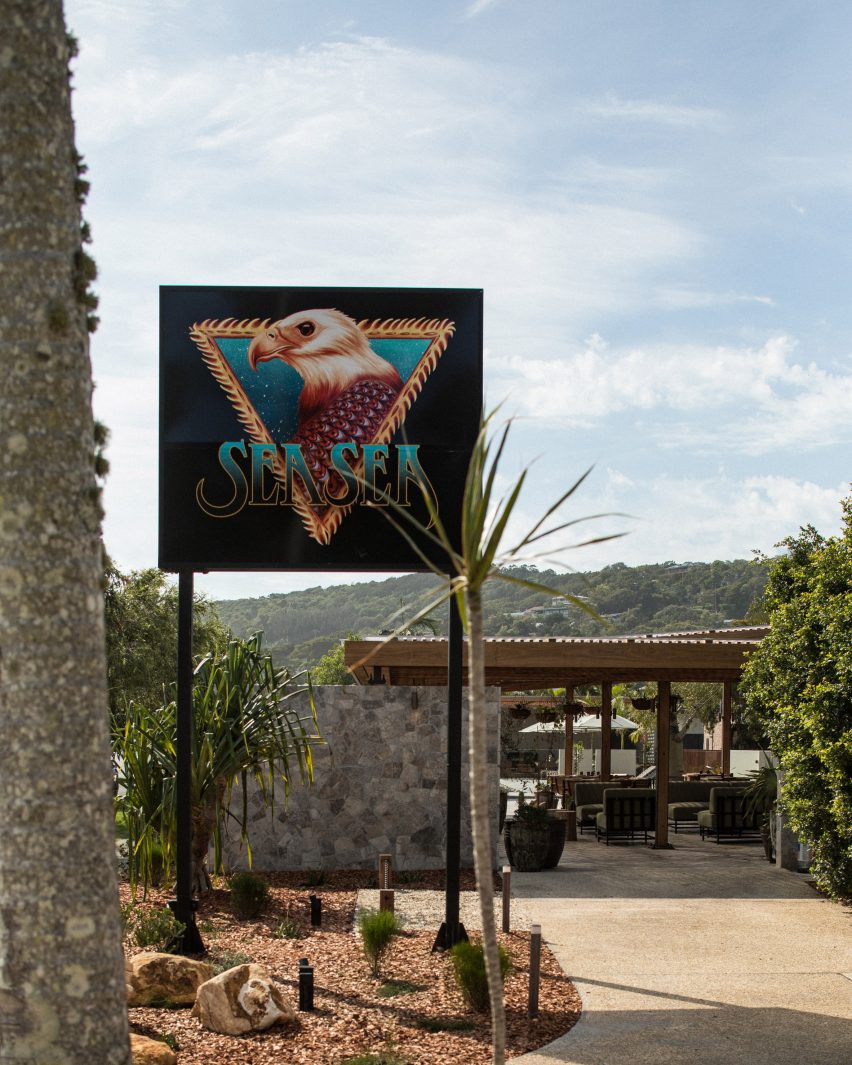 Motel driveway with cactus, palms and large sign saying Sea Sea