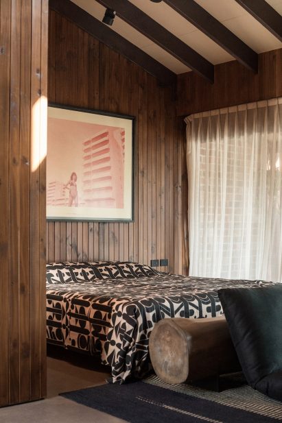 Bedroom with patterned throw on bed and floor sofa made from cushions