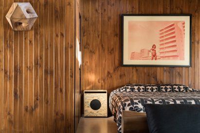 Bedroom with wood panelling and side table speaker