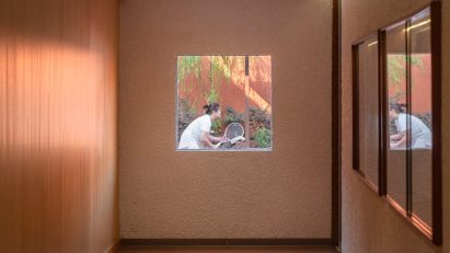 Tennis player viewed through window