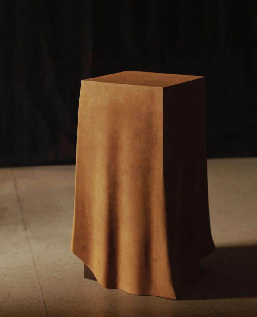 Photo of the Duk x Reishi pedestal, showing what looks like a tablecloth draped over a tall rectangular prismatic plinth, although the top is actually a sculpted form that is rigid and umoving