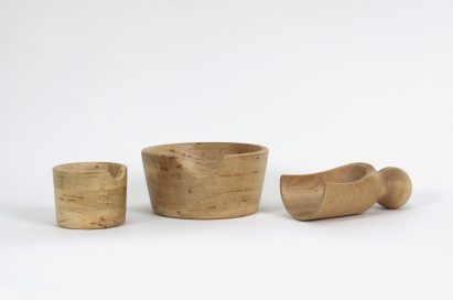 a photograph of a set of wooden vessels pictured against a white backdrop