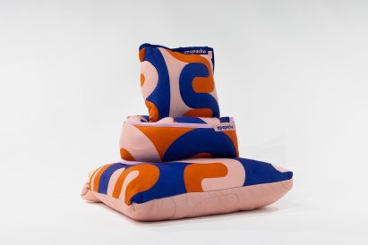 a photograph of a pile of cushions in colours of orange, blue and pink