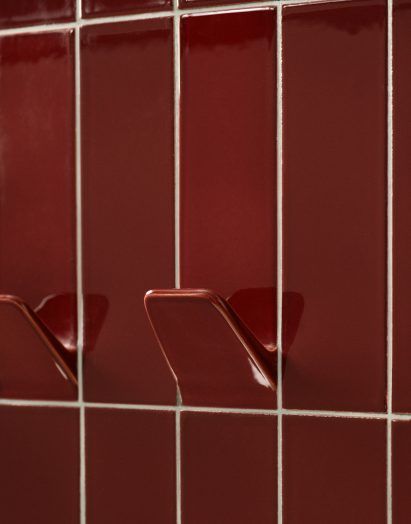 Close-up of hook coming out of red ceramic tile