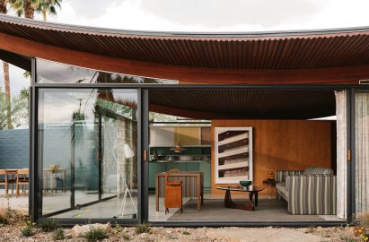 House with curved roof and sliding glass walls