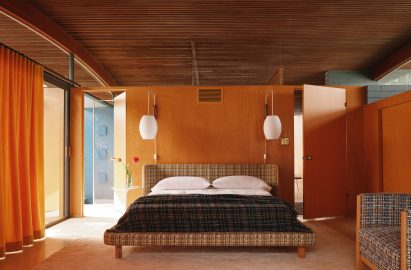 Bedroom with a plaid-covered bed and plywood walls