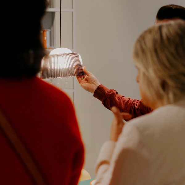 Photo of people looking at and holding a light by Hay