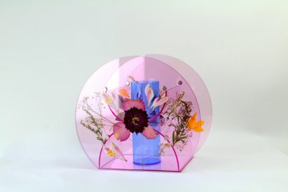 a photograph of a small vase in a circular form, in tones of pink and blue with floral patterns on it